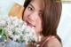 A young woman holding a bucket of flowers.
