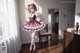 A woman in a red and white dress standing in a room.