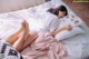 A woman laying on a bed reading a book.