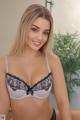 A woman in a white bra and black panties posing for a picture.