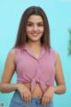 a woman in a pink top and jeans posing for a picture