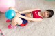 A young girl laying on the floor with a blue ball.