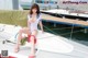 A woman in a sailor outfit sitting on a boat.